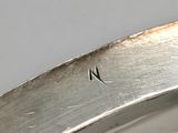 a close up of a silver plate with a small hole in the middle of it