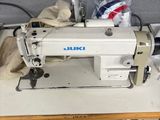 a white sewing machine sitting on a table in a room