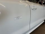 a close up of a white car with a sticker on it