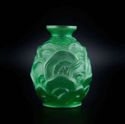 un vase vert posé sur une surface noire