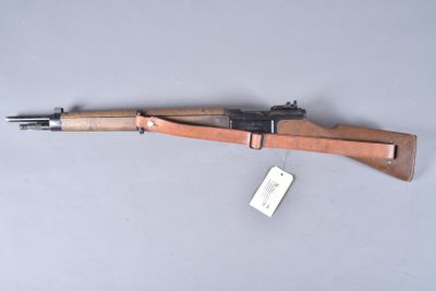 an old rifle with a wooden barrel on a gray surface