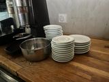 a stack of plates and a bowl on a counter