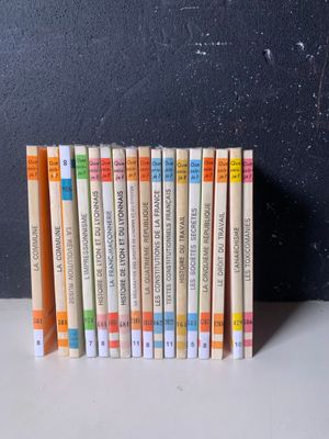 une pile de livres posée sur une table à côté d'un tableau noir