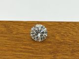 a single diamond sits on a wooden table