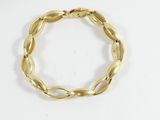 a close up of a gold bracelet on a white surface