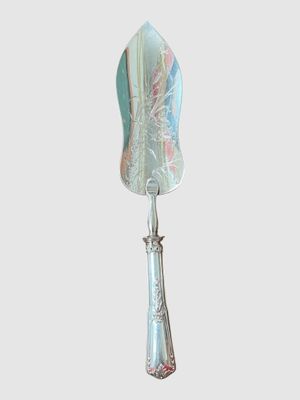 une cuillère en argent avec un manche bleu sur fond blanc