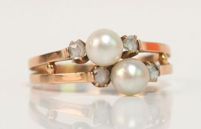 une photo en gros plan d'une bague ornée d'une perle et de diamants