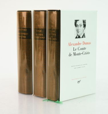 three books sitting on top of each other on a white surface