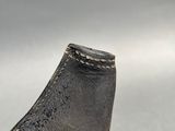 a close up of a metal object on a white surface