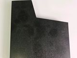 a close up of a piece of black paper on a white surface