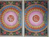 painting on the wall of a building with two different designs on it