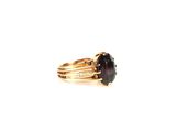a close up of a ring with a black stone on it