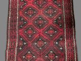 a red and black rug with a diamond design on it