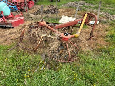 un tracteur qui se trouve dans l'herbe, avec une charrue attelée