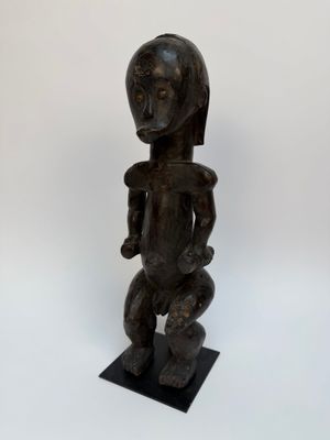 une statue en bois représentant une femme tenant un bébé dans ses bras