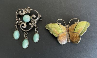 two pieces of jewelry sitting on top of a black surface