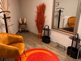 a chair and a mirror in a room with wood flooring