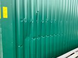 a large green container sitting on a pallet in a warehouse