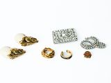 some gold and silver jewelry on a white surface