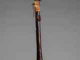 a close up of a wooden stick with a bird on it