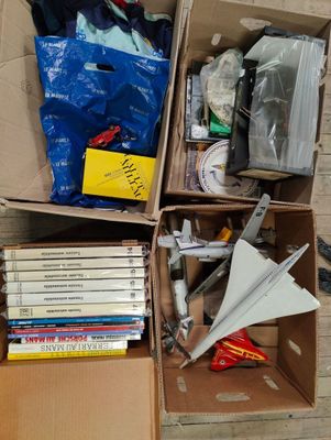 une boîte remplie de livres, avec un avion en papier à l'intérieur