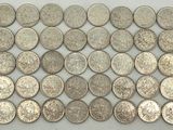 a close up of a pile of silver coins on a table