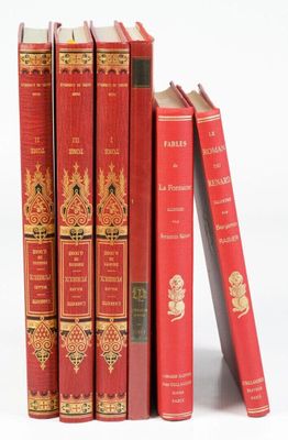 Plusieurs livres rouges sont empilés les uns sur les autres sur une surface blanche
