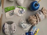 une table sur laquelle se trouvent un tas de pelotes de laine, des ciseaux et d'autres objets