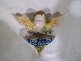 une figurine représentant un ange posée sur un tissu bleu et blanc