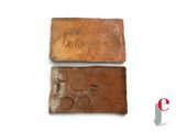 two bricks with writing on them sitting next to each other