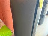 a black refrigerator sitting on the floor next to a pile of rice