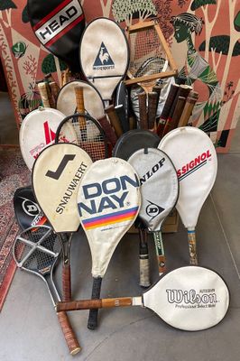 de nombreuses raquettes de tennis posées par terre