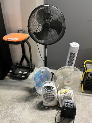 Il y a de nombreux types de ventilateurs posés au sol dans cette pièce.
