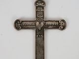 a silver cross with a cross on it on a white surface