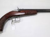 an old gun with a wooden handle on a white surface