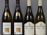 several bottles of wine are lined up on a glass table