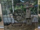 a man taking a picture of a clock in a mirror