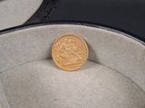 une pièce d'or posée dans un étui noir