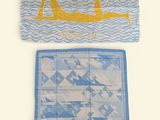 two towels with a picture of a woman in a boat on them