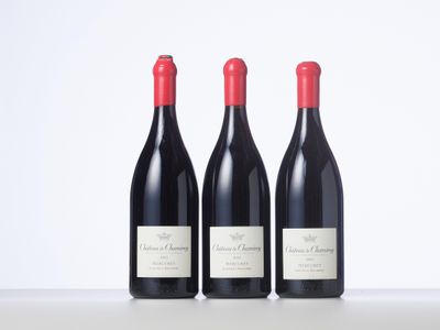 trois bouteilles de vin rouge sont alignées sur une table