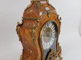 a clock that is sitting on a table next to a vase