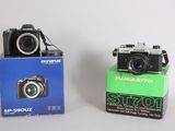 two cameras sitting next to each other on a table
