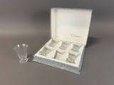 a box with four shot glasses in it and a shot glass next to it
