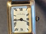 a silver watch with roman numerals on the face