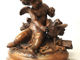a small statue of a boy with a bird on a pedestal