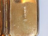a gold plated watch sitting on top of a white table