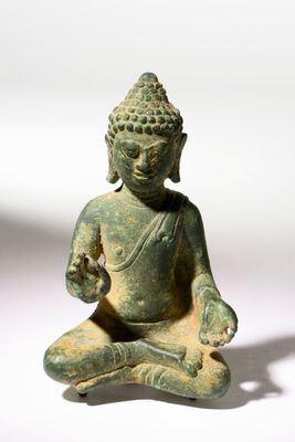 statue représentant une personne assise en position du lotus sur une surface blanche