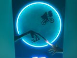 enseigne au néon représentant une personne à vélo devant une lumière bleue