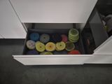 a drawer full of different colored dishes in the kitchen