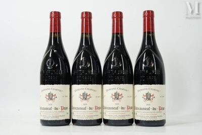 four bottles of red wine are lined up on a table